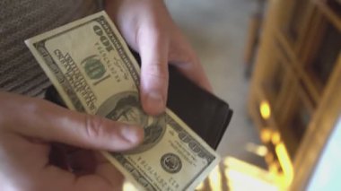 Cüzdandan 4 dolarlık banknotları çıkar.