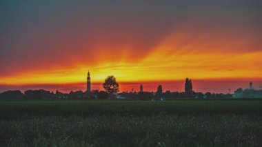 Çan kulesi, ağaçlar ve kırsal alanda gün batımı