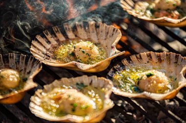 Izgarada dumanlı lezzetli neşterler, deniz tarakları.