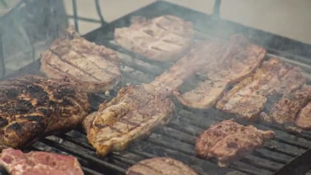 肉は火と煙でグリルで調理されます — ストック動画