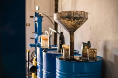 Bir atölyede kullanılmış motor yağı koleksiyonu, kullanılmış yağ fıçısı.