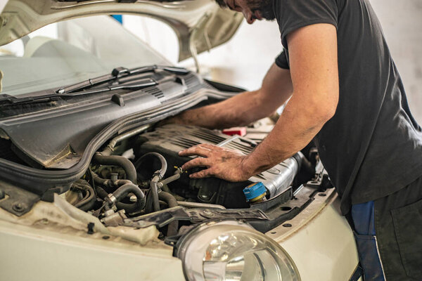 MILAN, ITALY 14 JULY 2021: Mechanic repair Detail of Engine powered by methane in a workshop