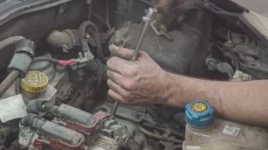 Tamirci elleri arabanın motorunda.
