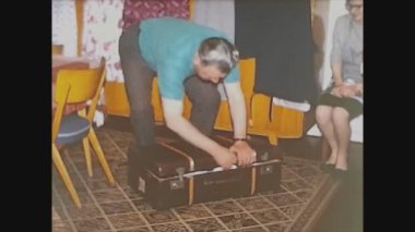 LLORET DE MAR, SPAIN 1965: İnsanlar bavullarını 60 'ların gezisi için hazırlıyorlar