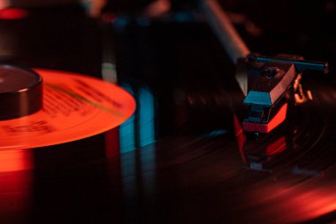 Plak tablosundaki vinil kaydındaki iğne detayı, yansımalı düşük ışık görüntüsü