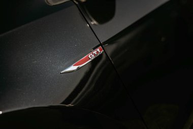 Rome, italy 10 september 2025: volkswagen gti emblem on a modern dark metallic car body, symbolizing performance, sport, and automotive engineering detail