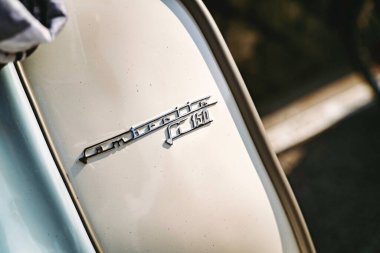 Rome, italy 10 september 2025: lambretta li 150 vintage scooter chrome badge with model number and logo, close-up detail reflecting warm light and italian design