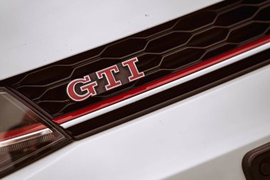 Rome, italy 10 september 2025: volkswagen golf gti emblem displaying red lettering on the front grille of a white car, highlighting automotive design and branding