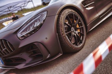 Rome, italy 10 september 2025: matte gray mercedes-amg gt coupe close-up of wheel, brake and headlight details at an outdoor automotive show, luxury performance