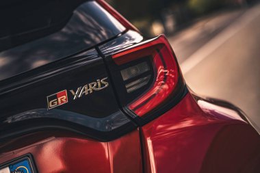Rome, italy 10 september 2025: red toyota gr yaris rear three-quarter view highlighting glossy taillight, gr emblem and sporty compact hatchback design on street