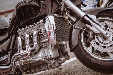 Rome, italy 10 september 2025: triumph rocket iii engine close-up with polished chrome, radiator grill and partial front wheel and brake, vintage-modern cruiser detail