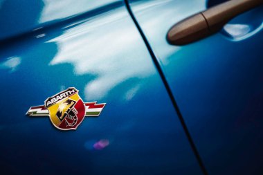 Rome, italy 10 september 2025: abarth scorpion emblem on glossy blue car door next to handle, metallic badge conveying italian performance, sport and luxury style