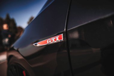 Rome, italy 10 september 2025: black volkswagen golf gti side panel close-up highlighting the iconic red and chrome gti performance badge and sleek black paint finish