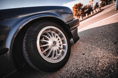 Rome, italy 10 september 2025: bmw vintage classic car wheel and tire on asphalt road, close-up of detailed rim, brake disc and tire tread in daylight