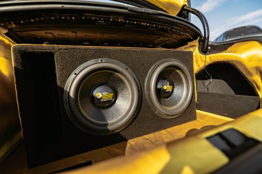 Rome, italy 10 september 2025: car trunk with custom car audio installation featuring dual powerful subwoofers, amplifier and bold yellow-black design for amplified bass