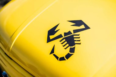 Rome, italy 10 september 2025: abarth black scorpion emblem on a vivid yellow car fender, close-up highlighting italian performance heritage and sporty design details