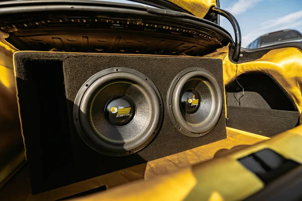 Rome, italy 10 september 2025: car trunk with custom car audio installation featuring dual powerful subwoofers, amplifier and bold yellow-black design for amplified bass