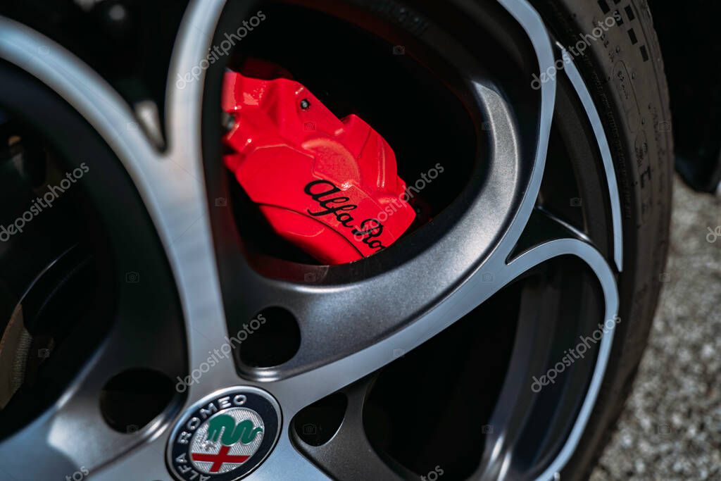 Rome, italy 10 september 2025: alfa romeo alloy wheel and polished rim with red high-performance brake caliper and branded center cap, close-up automotive detail