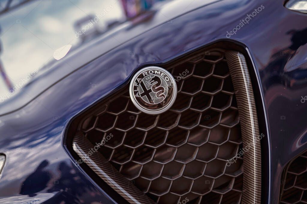 Rome, italy 10 september 2025: alfa romeo emblem centered on dark blue hood with prominent hexagonal grille and carbon fiber trim, close-up luxury detail