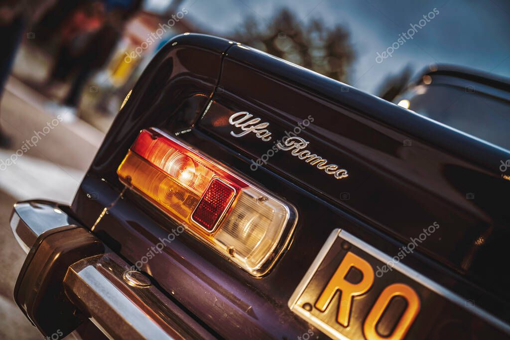 Rome, italy 10 september 2025: classic alfa romeo rear detail: glossy taillight, chrome bumper and emblem evoking vintage italian style, heritage and automotive elegance