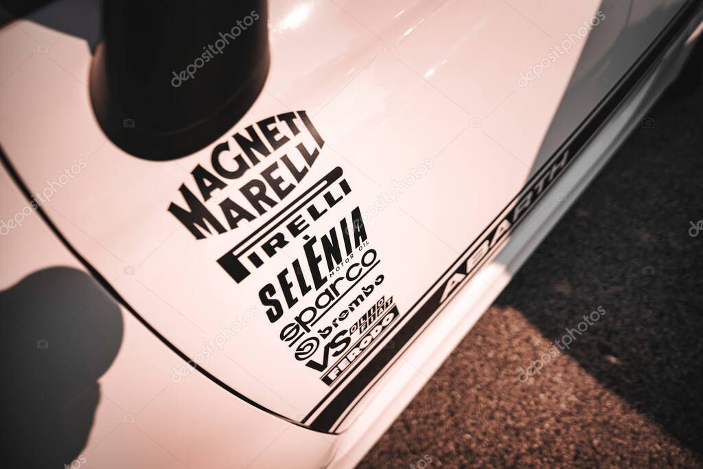 Rome, italy 10 september 2025: abarth racing car side view covered in sponsor logos and stickers, showcasing motorsport branding, performance and speed in close detail