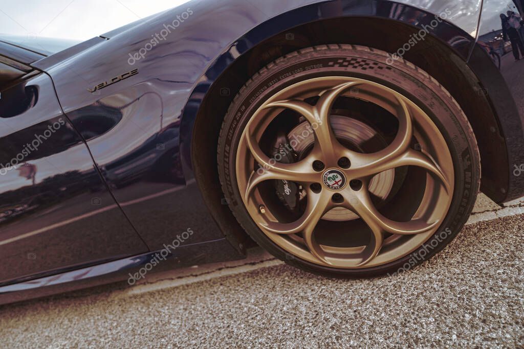Rome, italy 10 september 2025: alfa romeo veloce in dark blue showcasing shiny gold multi-spoke alloy wheel with brand logo and sporty elegant design