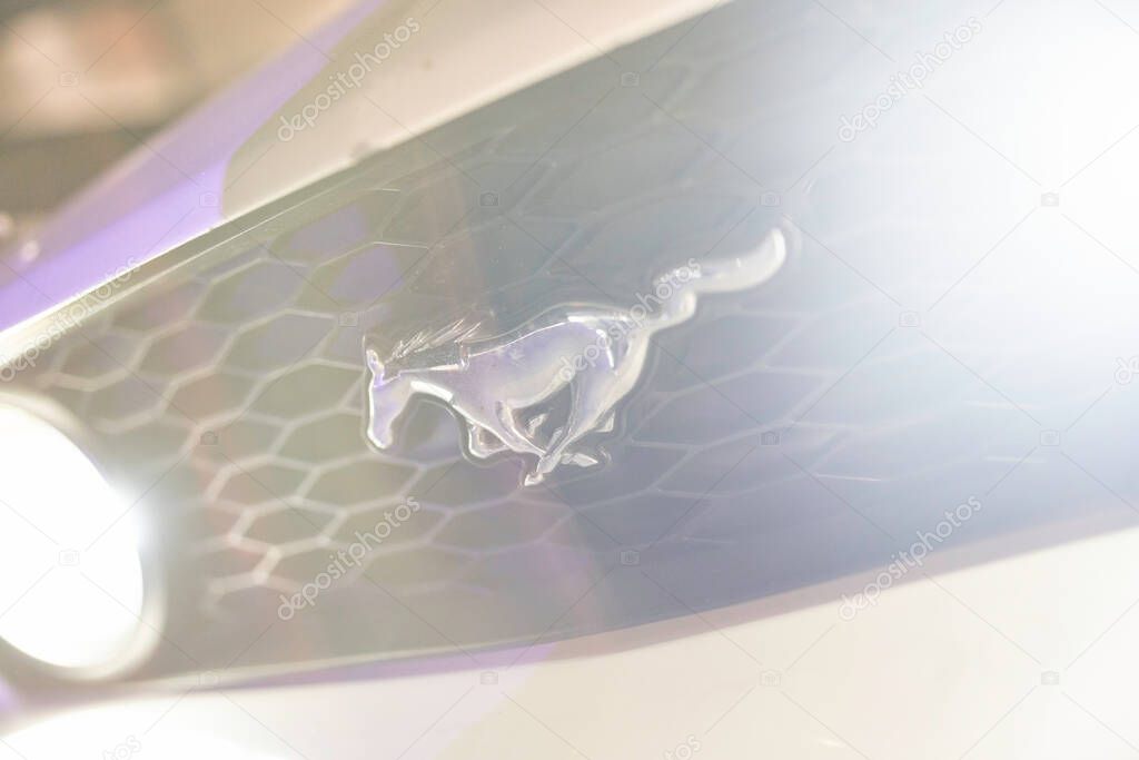 Este, italy 28 october 2025: ford mustang running pony emblem on the front car grille, reflecting light near a bright headlight. Celebrating automotive design