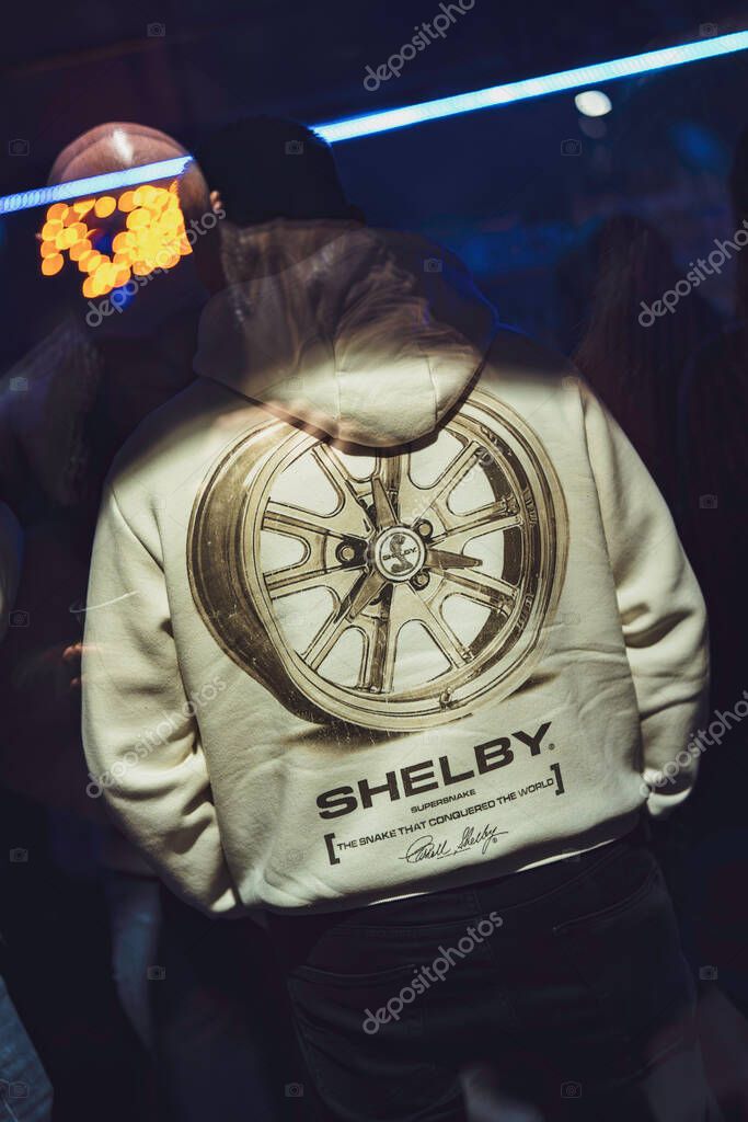Este, italy 28 october 2025: man seen from behind wearing shelby hoodie with large car wheel graphic, urban streetwear vibe conveying automotive passion and racing identity