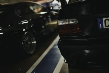 Milan, İtalya 28 Ekim 2025: Yeraltı otoparkında yan yana park edilmiş siyah BMW sedanları, arka far, krom detaylar ve plakalar sergileniyor.