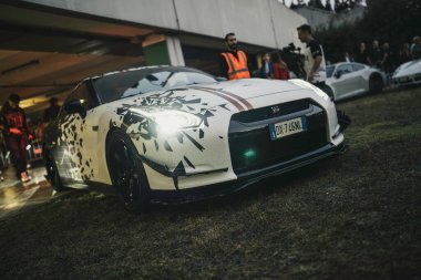 Milan, İtalya, 28 Ekim 2025: özel boyalı beyaz Nissan gt-r gece araba buluşmasında cesur tasarımı ile kalabalık, modifiye edilmiş gösteri arabası ve duruşu hayranlıkla toplandı