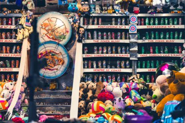 Milan, İtalya 27 Ekim 2025: Karnaval atış poligonu birden fazla hedef, sıra kutu ve renkli peluş oyuncak koleksiyonu sergiliyor.