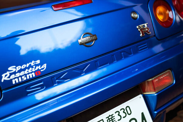 Milan, italy 28 october 2025: blue nissan skyline gt-r r34 rear close-up with nismo badge and sports resetting sticker, highlighting jdm tuning performance and detail