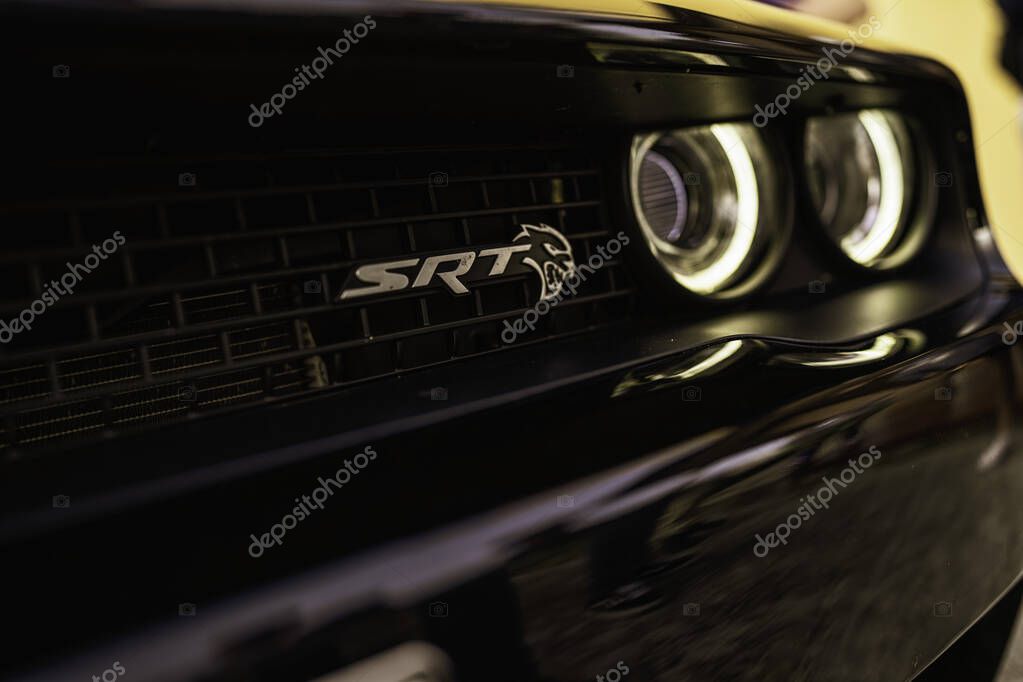 Milan, italy 28 october 2025: dodge challenger srt hellcat front grill featuring the srt emblem and glowing headlights, representing power and performance