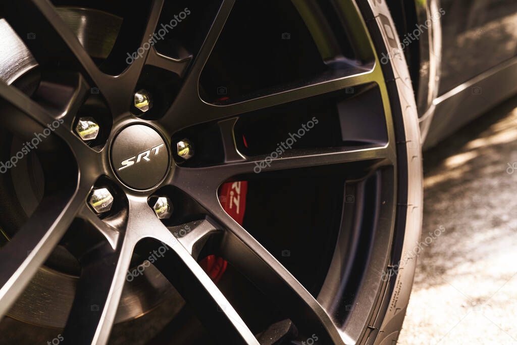 Milan, italy 28 october 2025: up-close view of a dodge challenger srt wheel, black rim, and red brembo brake caliper, highlighting power and performance