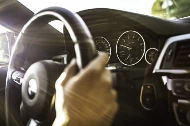 Vo, italyan 28 Ekim 2025: bmw direksiyon simidi üzerinde konsol göstergeleri açık, güneşli bir sürüş üzerinde güneş ışığı parlaması