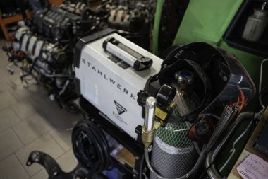 Roma, İtalya, 20 Kasım 2025: kaynaklama ekipmanı ve araba motoru bir otomotiv garajında tamir ve bakım için söküldü. Profesyonel otomobil mekaniği için endüstriyel metalcilik araçları