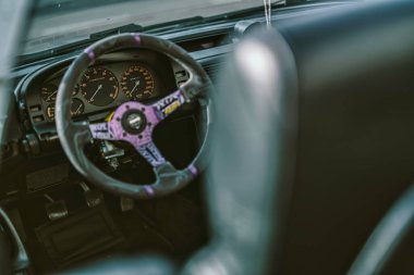 Vo, İtalya 28 Ekim 2025: Bir performans arabasının içindeki özel direksiyon ve gösterge paneli göstergeleri, akort kültürünü ve araç kişiselleştirmesini vurguluyor