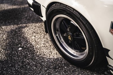 Vo, italy 28 Ekim 2025: Porsche 911 klasik tekerlek yakın çekim: lastik, krom jant ve çamurluk detay Sunlit sokak asfalt karşı, klasik spor araba zarafeti