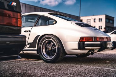Vo, italyan 28 Ekim 2025: Porsche 911 antika beyaz spor araba güneşli klasik bir araba toplantısında asfalta park edilmiş, ikonik Alman tasarımı ve stili sergileniyor.