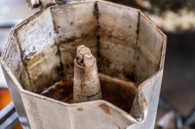 İçi koyu kahve lekeleri ve üst odasında kalıntı olan eskimiş moka demliği günlük İtalyan sobası mayalama, gübre ve otantik sabah ritüelini gösteriyor.