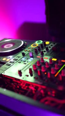 Roma, İtalya, 2 Ocak 2026: Bir DJ 'in ellerini ustalıkla bir karıştırma konsolunun kontrollerini manipüle ederek bir gece kulübündeki hareketli bir parti için müzik yaratıyor.