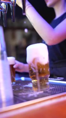 Roma, İtalya 2 Ocak 2026: profesyonel bayan barmen bir gece kulübünde ya da bir barda bardağa musluktan taze bira dolduruyor.