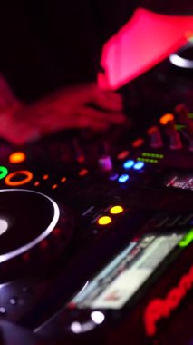 Roma, İtalya, 2 Ocak 2026: Karanlık bir kulüpte canlı performans sırasında profesyonel bir döner tablonun üzerinde, dövmeli bir disk jokeyinin ellerinin yakın çekimi