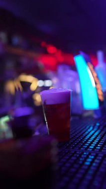 Roma, İtalya, 2 Ocak 2026: profesyonel barmen canlandırıcı bir alkollü içeceği kaşıkla karıştırıyor ve modern bir gece kulübünde limon dilimiyle süslüyor.