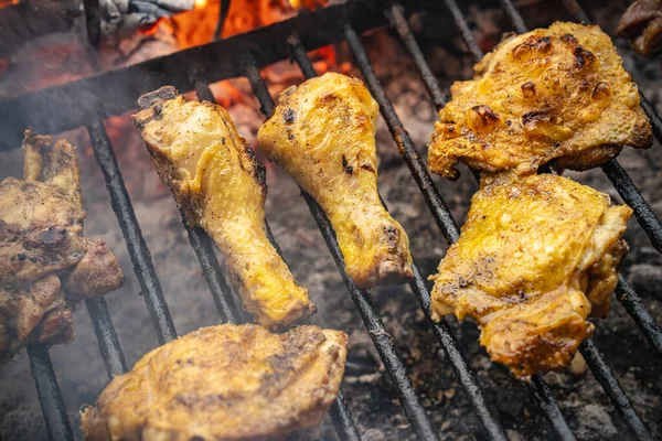 Tavuk budu, but, ve diğer parçalar sıcak kömür ızgarasında pişiyor, lezzetli etten dumanlar yükseliyor, dışarıda lezzetli bir barbekü yemeği hazırlıyor.