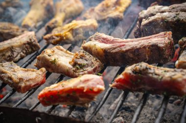 Domuz kaburgası ve tavuk budu da dahil olmak üzere çeşitli etler sıcak kömür ızgarasında pişiyor, dumanı yaratıyor ve açık hava barbeküsü sırasında lezzetli bir aroma yaratıyor.