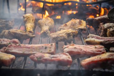 Arka bahçedeki kömür ızgarasında cızırdayan etler açık alevler üzerinde, tavuk ve pirzola dumanlı ve lezzetli bir şekilde kızartılıyor.