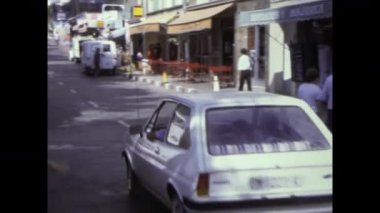 Mallorca, Haziran 1978: Balear Adaları 'ndaki bir İspanyol kasabasında güneşli bir günün arşiv görüntüleri. İnsanlar geziniyor ve arabalar cadde boyunca sürüyor.