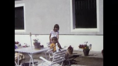 Atina, Yunanistan, Haziran 1980: Güneşli bir yaz gününde çocuklu bir aileyi verandada dinlenirken gösteren otantik süper 8 film. 1980 'de Yunanistan' dan nostaljik bir sahne