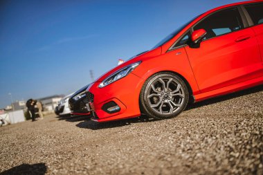Imola, İtalya 01 Ocak 2026: canlı kırmızı Ford Fiesta st-line spor duruşu ve özel alaşım tekerlekleri açık mavi gökyüzü altında buluşuyor.